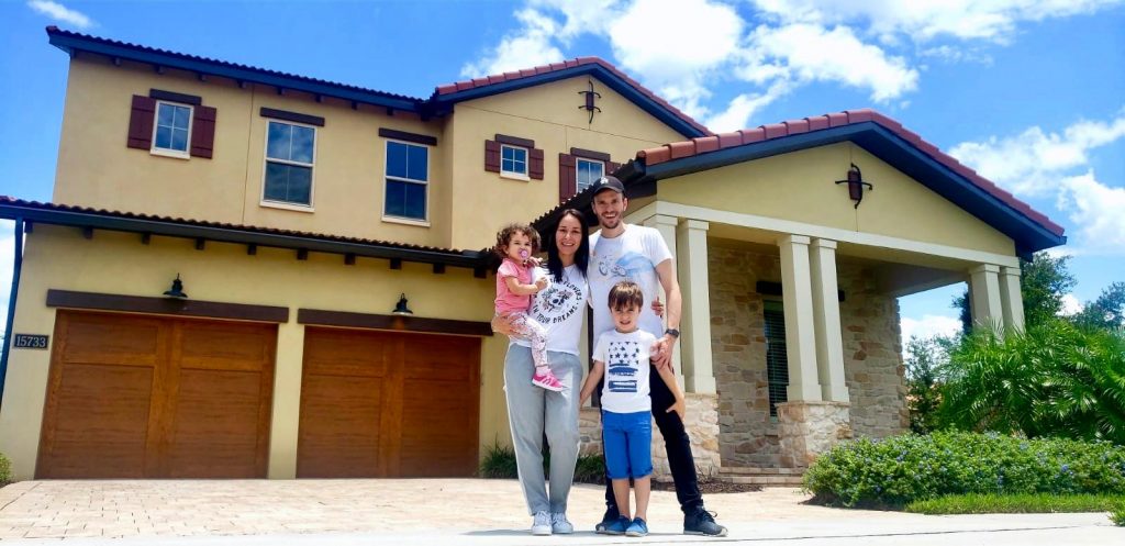 Família Brancoala morando nos Estados Unidos registra foto em frente em uma das casas que morou.