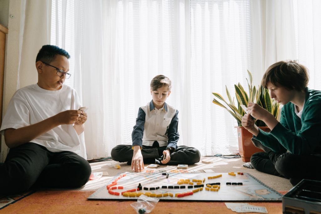 três meninos jogando jogos de tabuleiro.