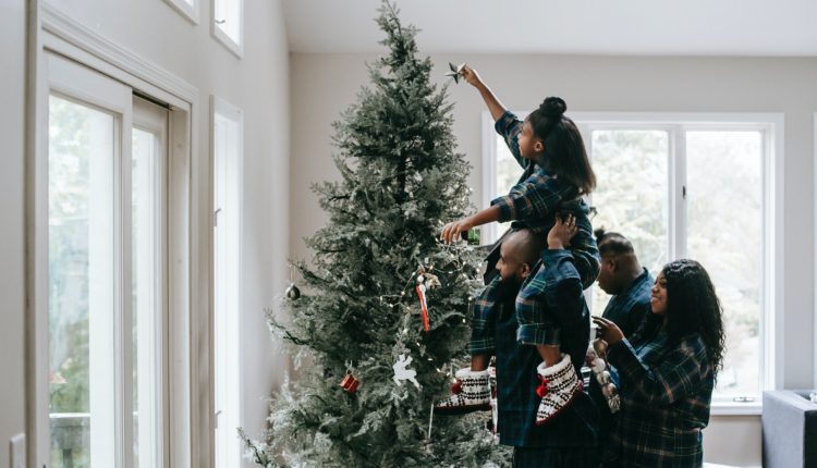 Família montando árvore, uma das tradições de natal mais comuns.
